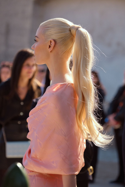 Anya TaylorJoy wears her hair in a long ponytail. She wears a peach silk dress.